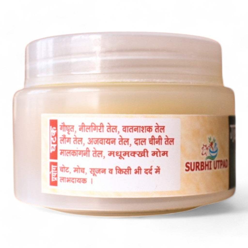 A jar of Surbhi Peedantak Ayurvedic Balm with a label detailing its ingredients (cow ghee, eucalyptus oil, clove oil, etc.) and uses for pain, swelling, and sprains.
