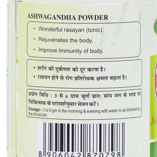 Label of Ashwagandha Powder container featuring bilingual text in Hindi and English. Highlights include benefits such as rejuvenation, immunity support, and rasayan properties. Dosage instructions recommend 3–6 grams in the morning and evening with water or as directed by a physician. Includes a barcode.