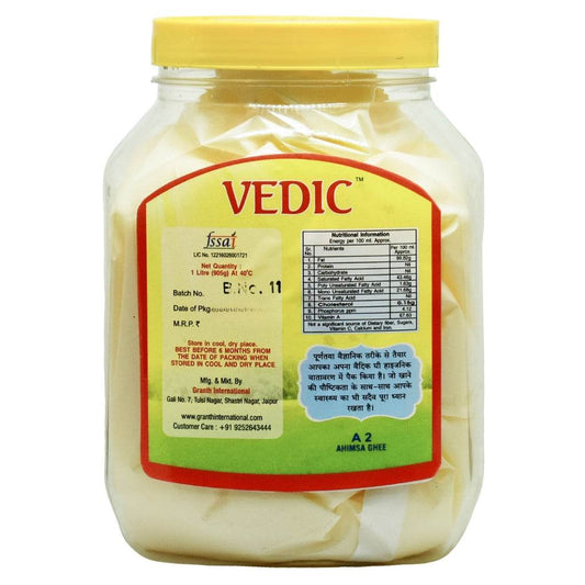 Transparent 1-litre jar of Vedic Ahimsa A2 Ghee with yellow lid and label featuring nutrition facts, storage instructions, and manufacturer contact—Granthit International, Jaipur.