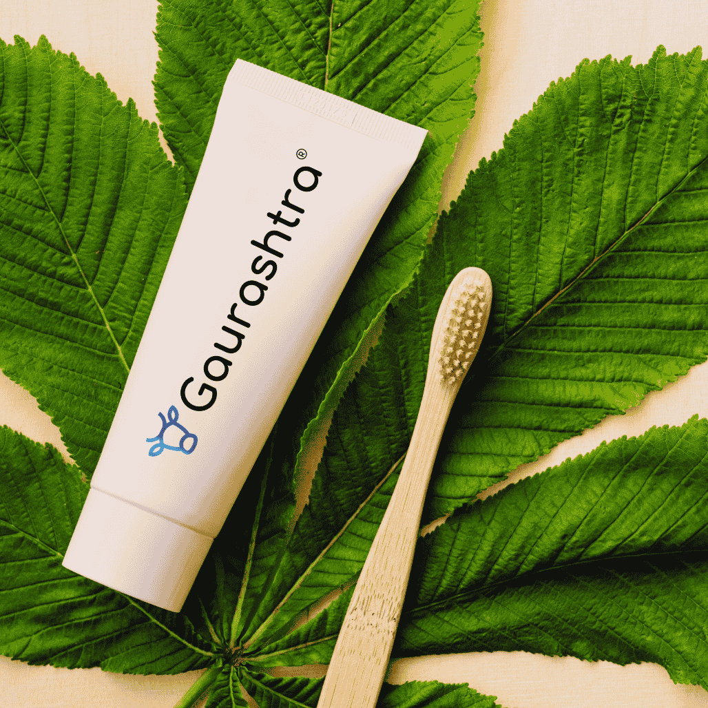 Toothpaste tube on a leaf with a bamboo toothbrush