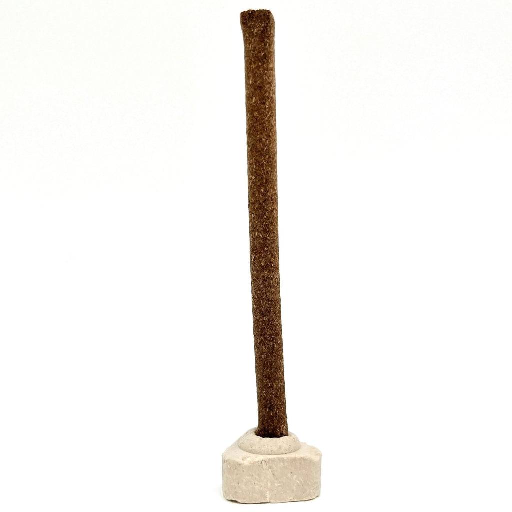 Single brown cow dung dhoop stick placed upright on a white base—crafted with natural material for spiritual rituals and eco-friendly indoor use.
